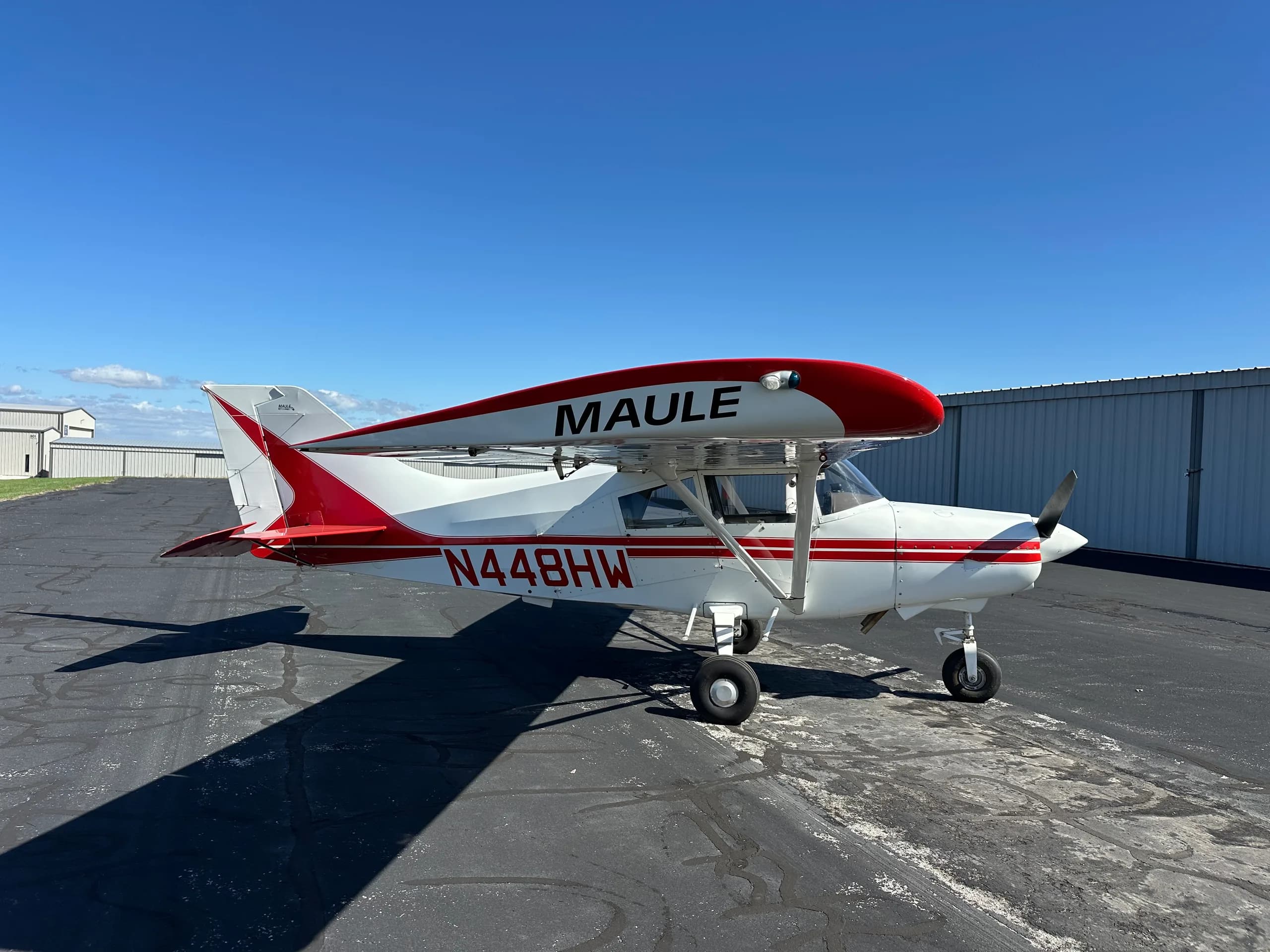 A Maute aircraft with red and white paint scheme is parked on the tarmac.