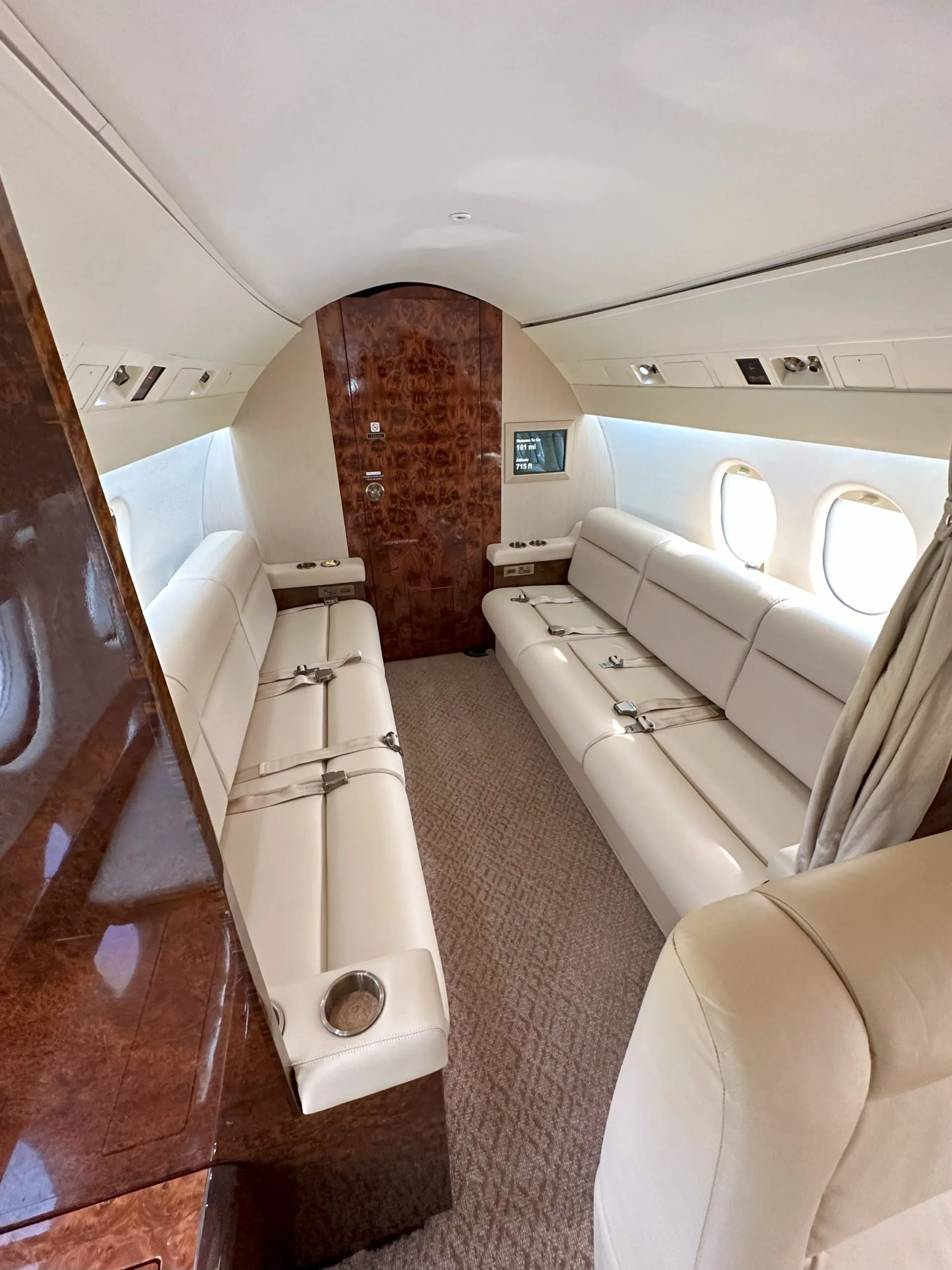 View down the aisle of the aircraft cabin with leather seats.