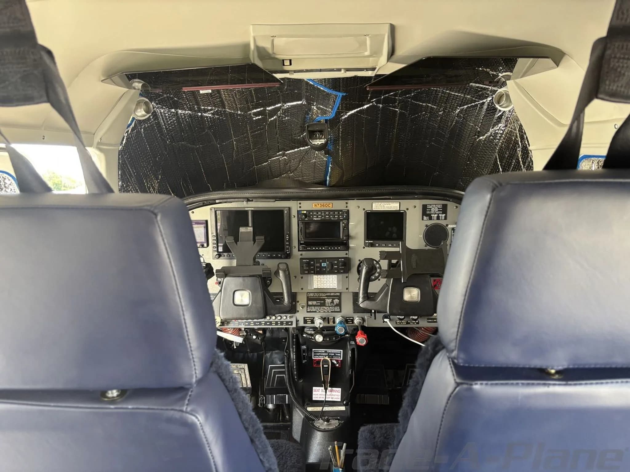 View from the cabin into the cockpit of Cessna N7360C, showing the instrument panel with sunshades.