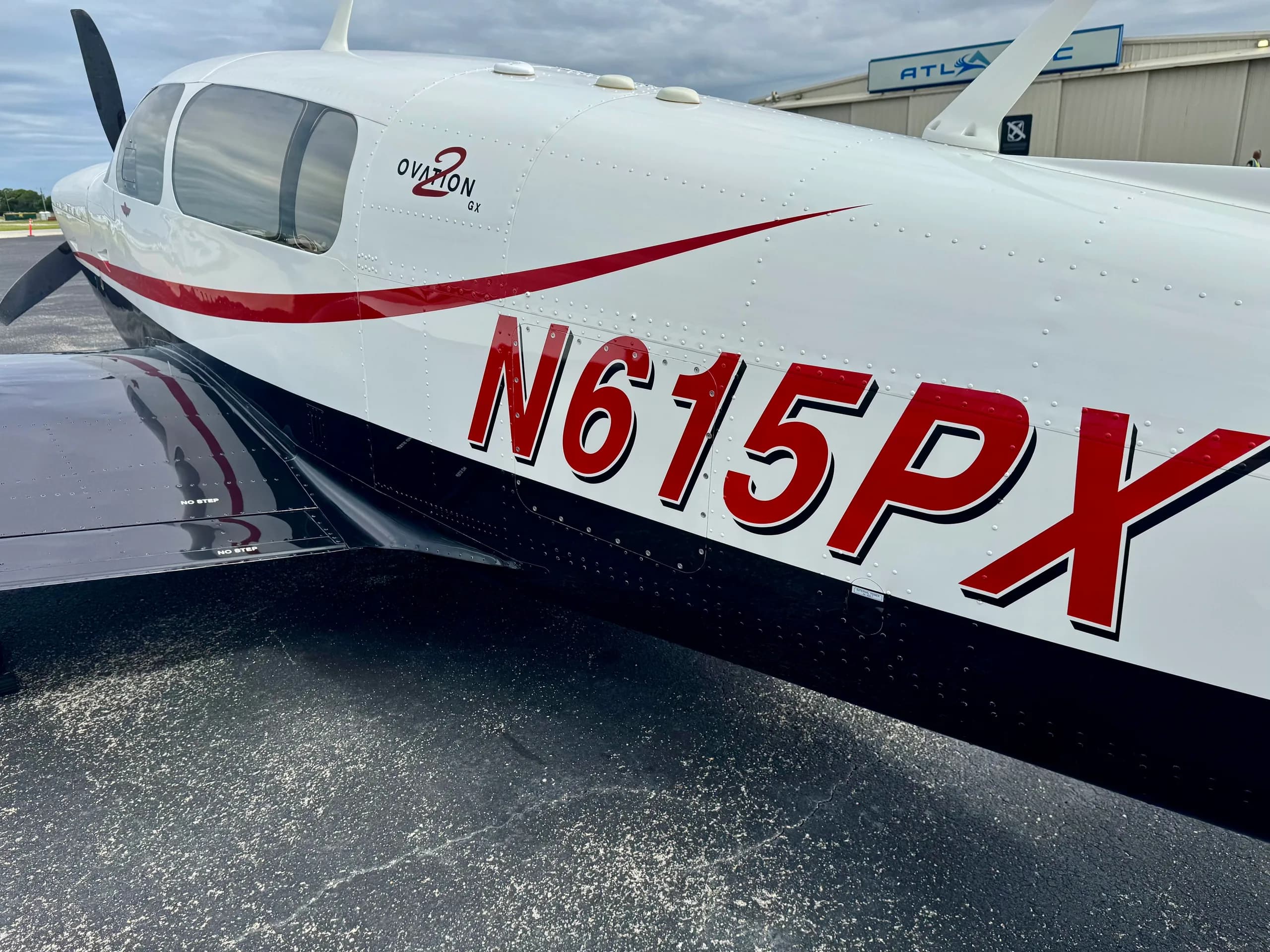 A close-up view of the fuselage of Mooney Ovation GX N615PX, showing the red N-number and "Ovation GX" branding.