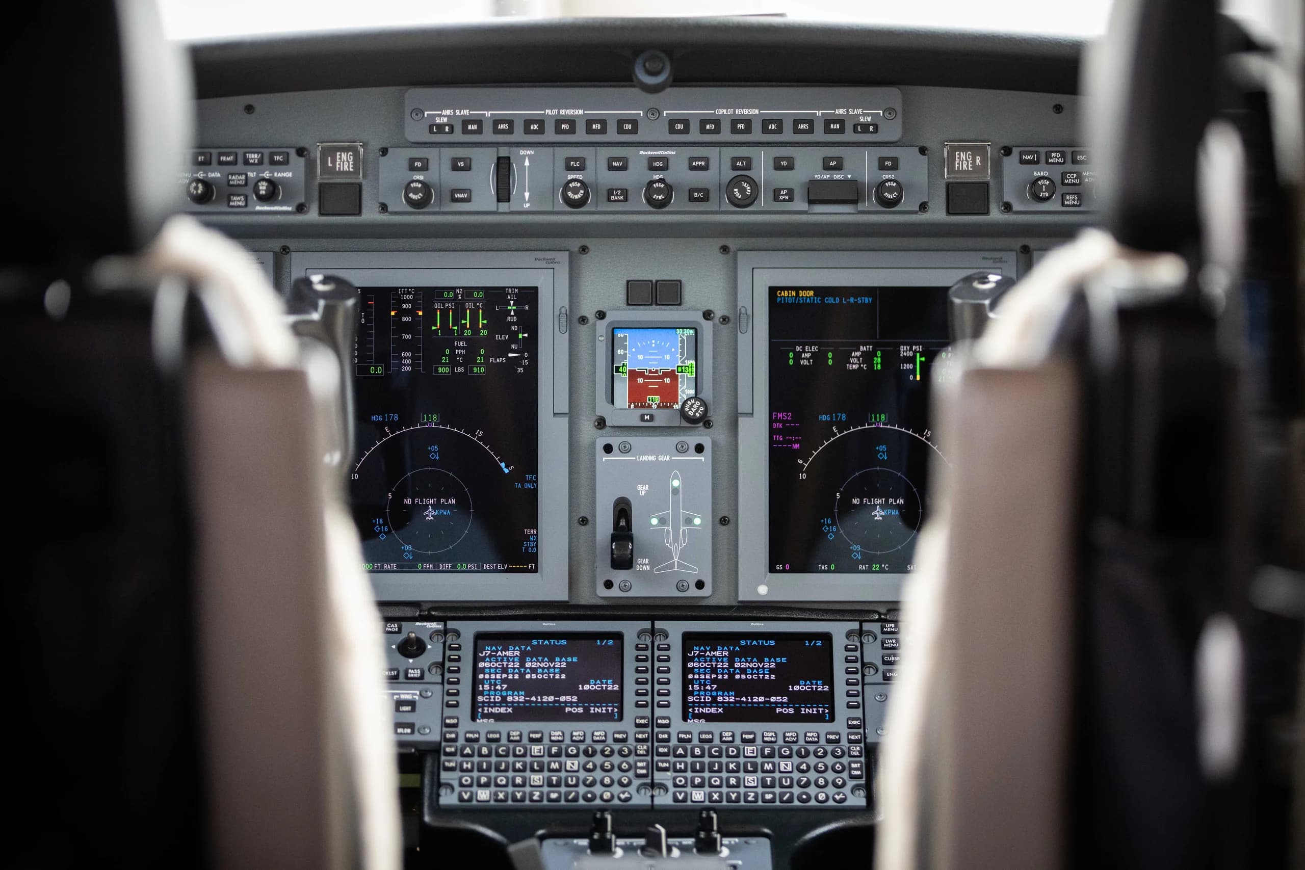 A wide view of a modern aircraft cockpit with multiple digital displays and control panels.