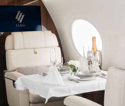 A white and blue jet with the door open on the tarmac.