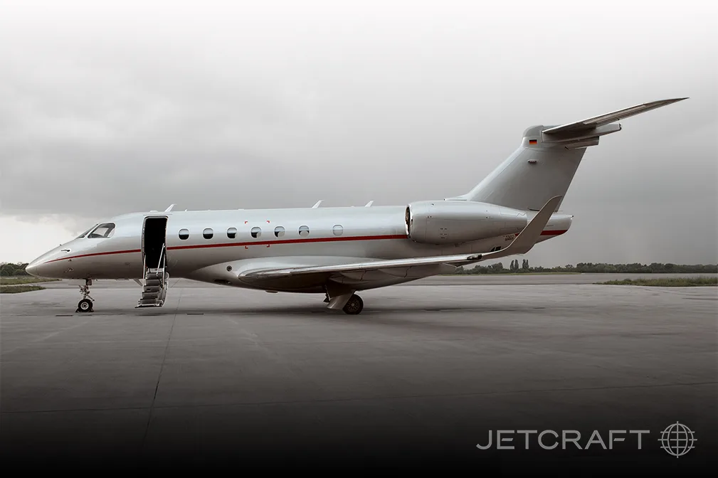 A silver jet aircraft with an open door and stairs extended.
