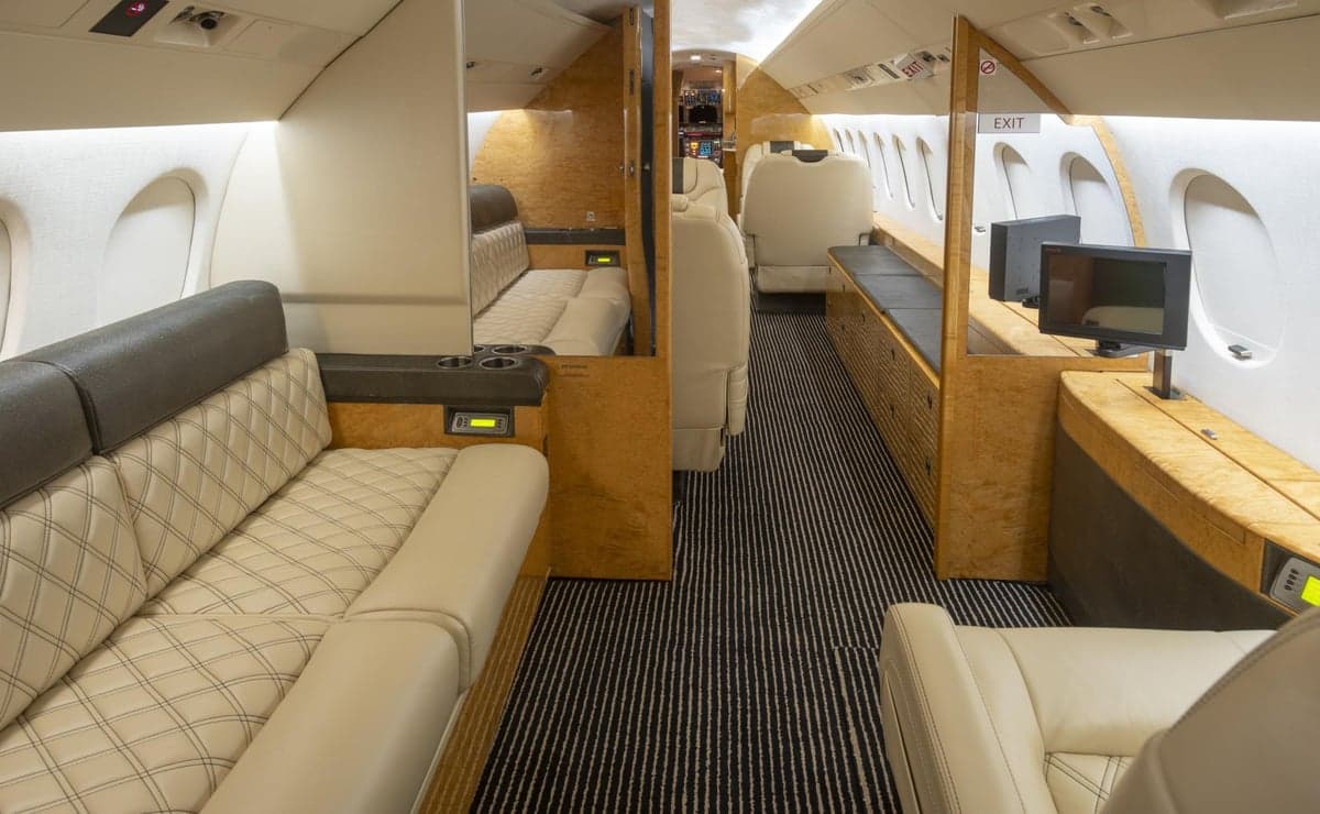 Interior view of the aircraft cabin with seats and a striped carpet.