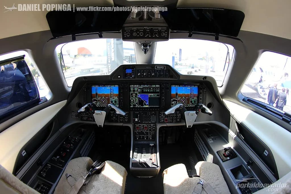 The cockpit of a Phenom 100 aircraft features advanced avionics and controls.