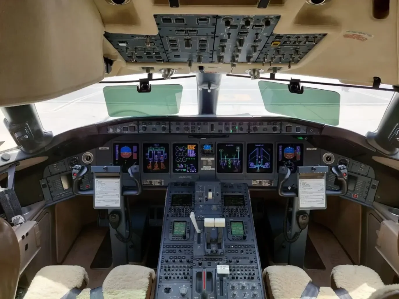 The cockpit of a Bombardier Global Express business jet showing the instrument panel and controls.