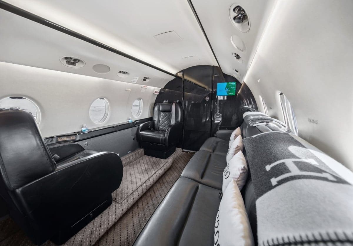 A view of the interior of the aircraft, showing the leather seats and a blanket.