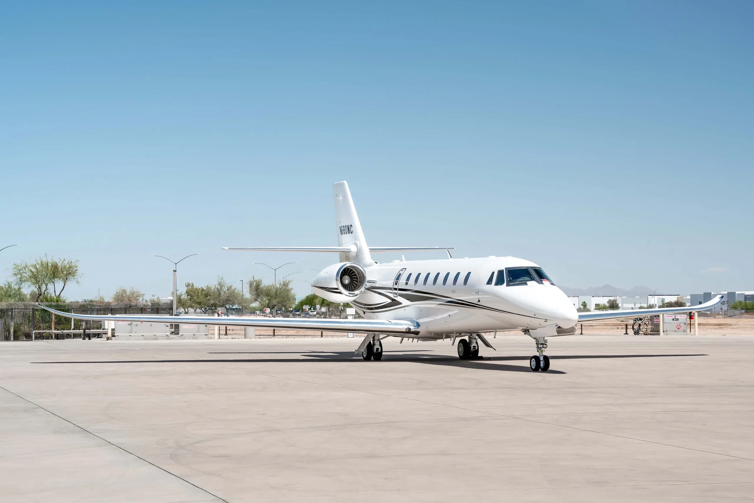 A front three-quarter view of a white Cessna Citation Latitude business jet, registration N680MC, parked on a sunny tarmac.