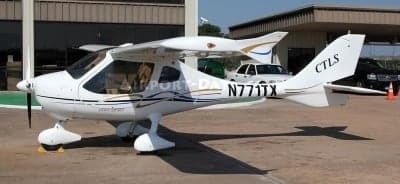 A white CTLS aircraft with registration N771TX is parked on the tarmac.