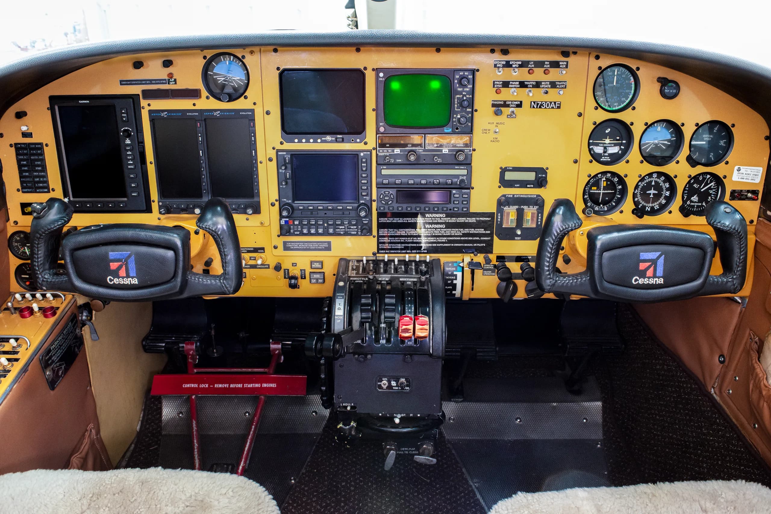 The cockpit of a Cessna aircraft with a yellow instrument panel and dual yokes.