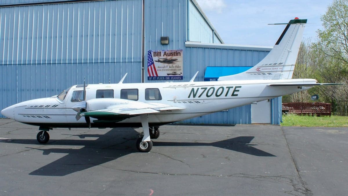 Aerostar Super 700 twin parked near a hangar.