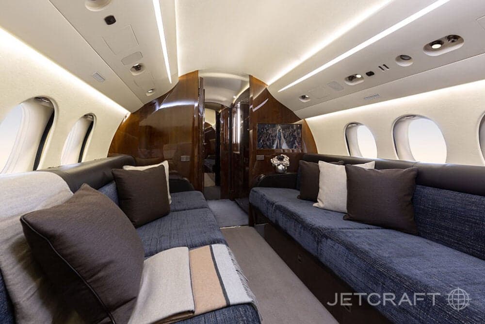 The aircraft's interior features a lounge area with comfortable seating.