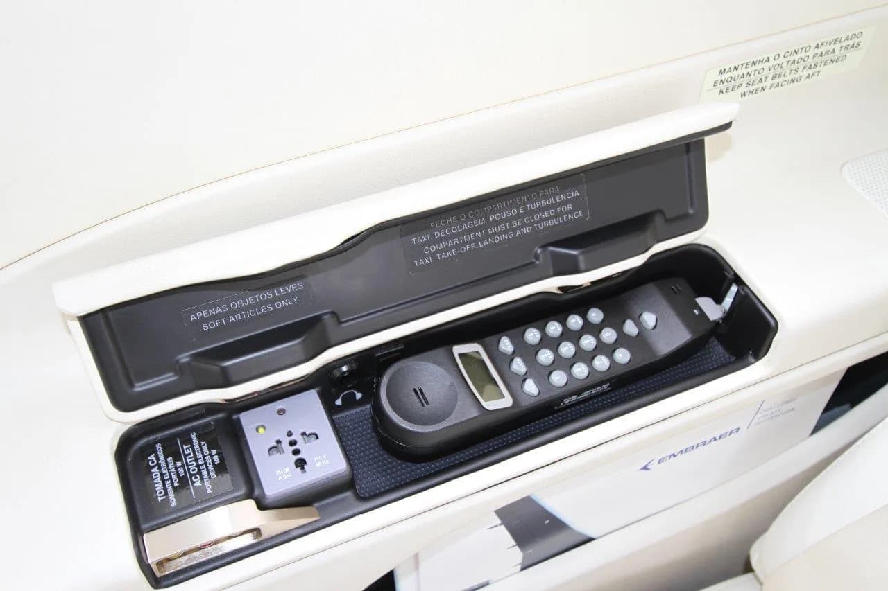 The Phenom 300E cabin features a storage compartment with a phone and power outlet.