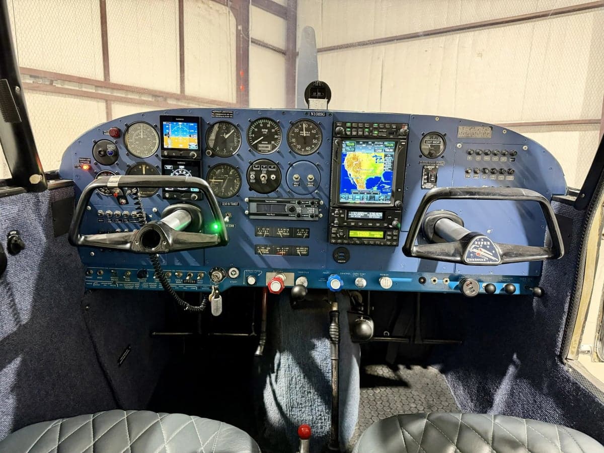 The cockpit of the Piper PA-28-140 Cherokee features a blue instrument panel and yokes.