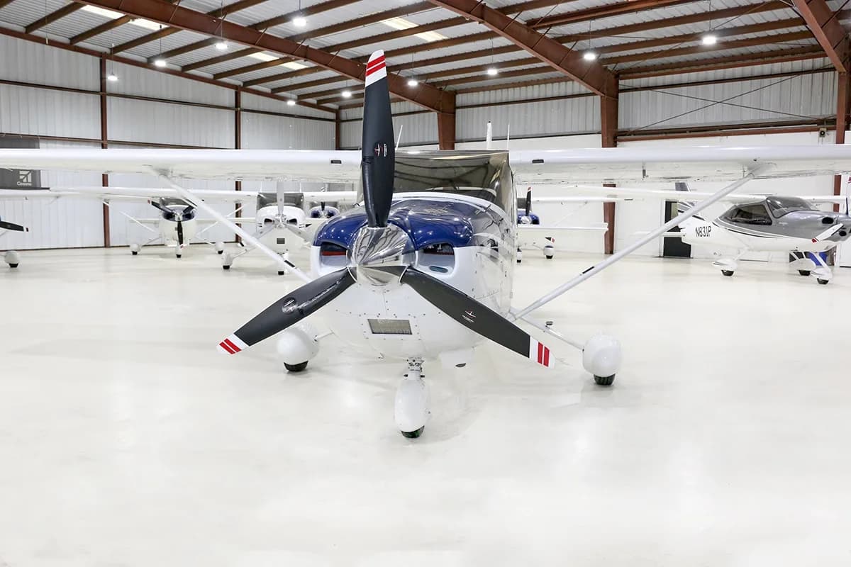 Head-on view of a white and blue Cessna Skylane TC (N2049P) in a hangar.