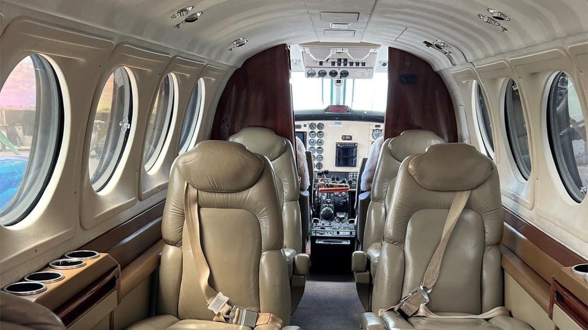 Cabin view of the Beechcraft King Air with leather seats and wood trim.