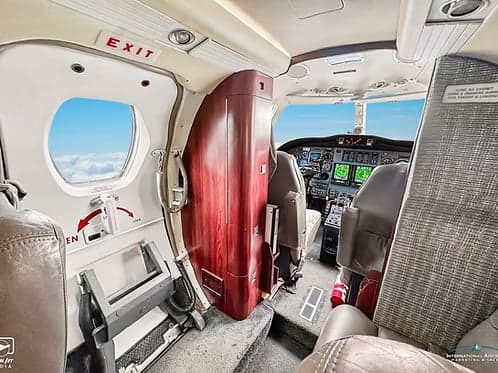View of the aircraft interior, showing the exit door and cockpit.