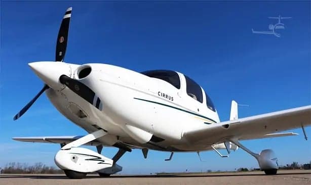 A Cirrus SR20 aircraft is parked on the tarmac.