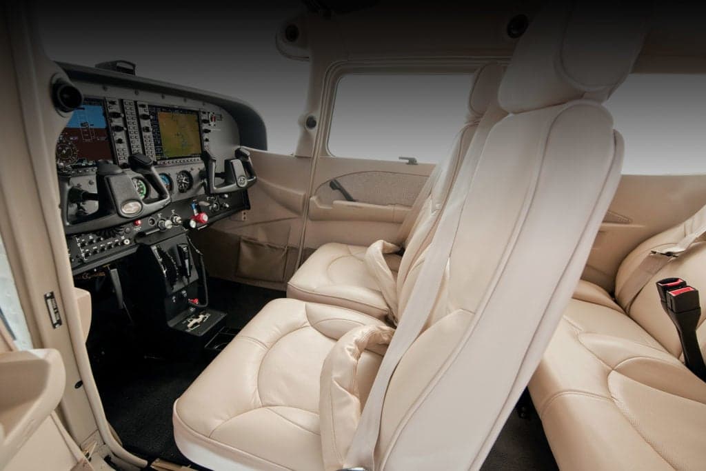 View of the aircraft's interior, showing the front seats and cockpit.
