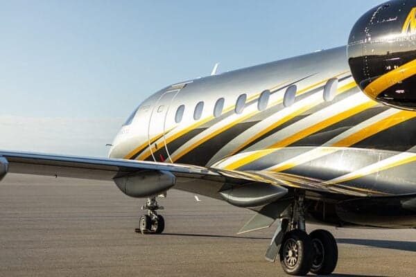 A side view of the fuselage and wing of the Embraer Legacy 500, highlighting the windows and landing gear.