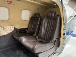 A view of the aircraft's interior, featuring brown leather seats and side paneling.