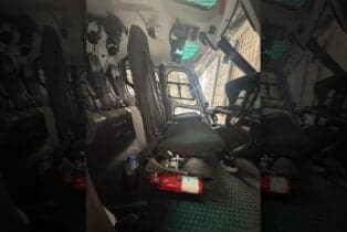 View of the helicopter's interior with seats and fire extinguisher.
