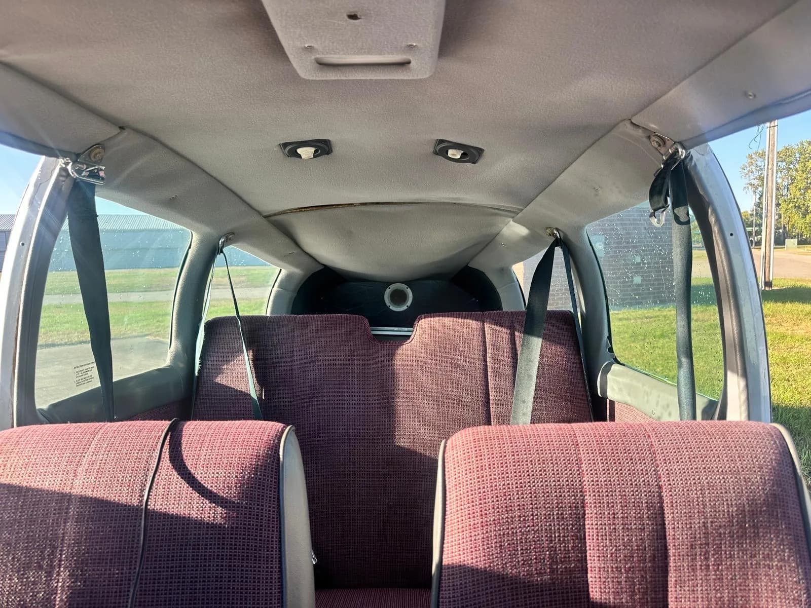 View of the maroon fabric rear seats and cabin interior of the aircraft.