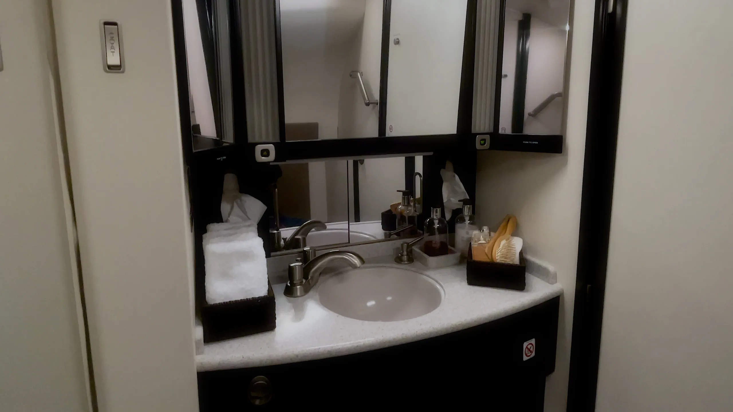 The lavatory area of a business jet, featuring a sink, mirror, and amenities.