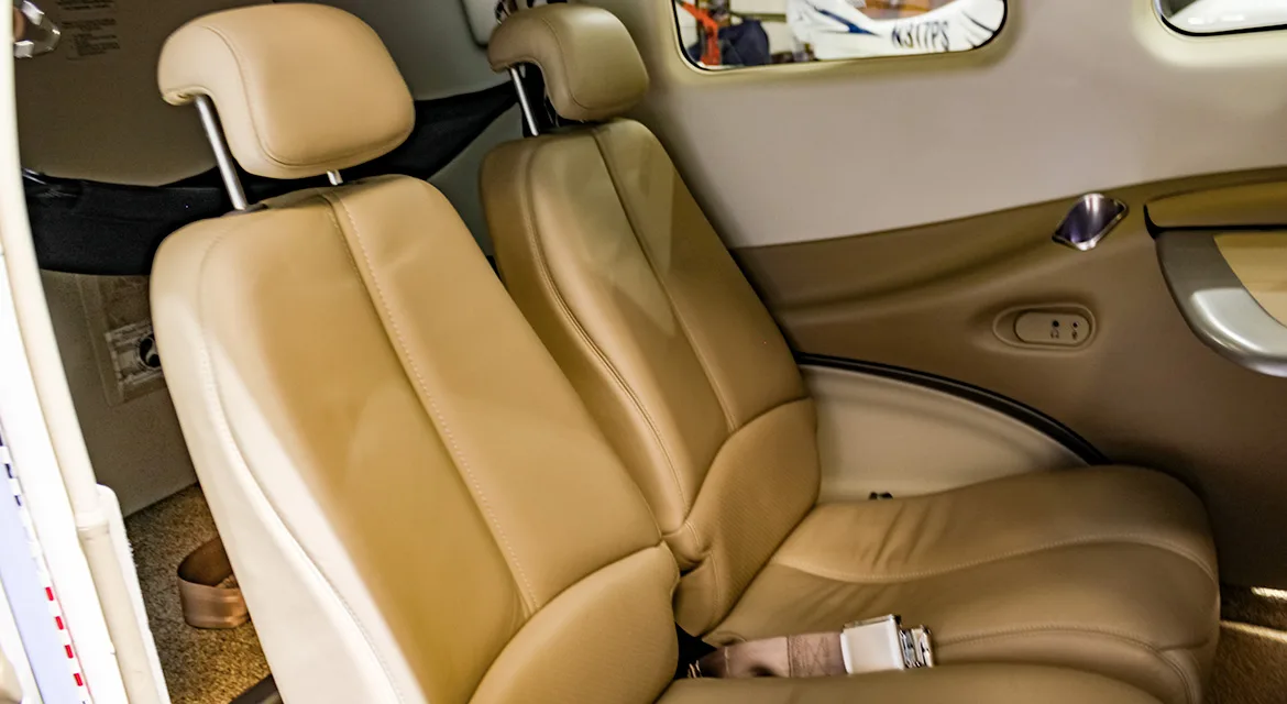A close-up view of the tan leather passenger seats in the cabin of a Beechcraft Baron G58.