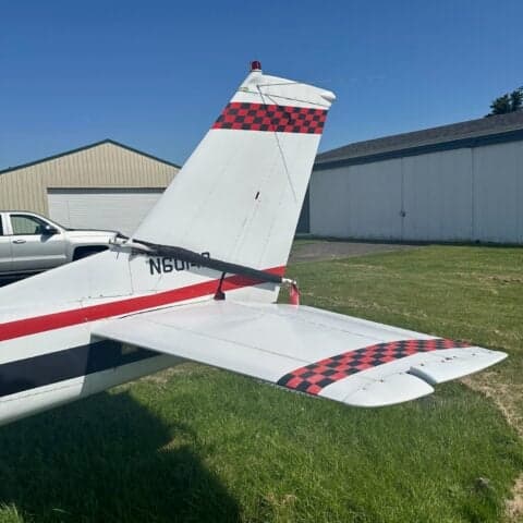 The tail section of a Cessna 150 aircraft with a red and black checkered pattern.