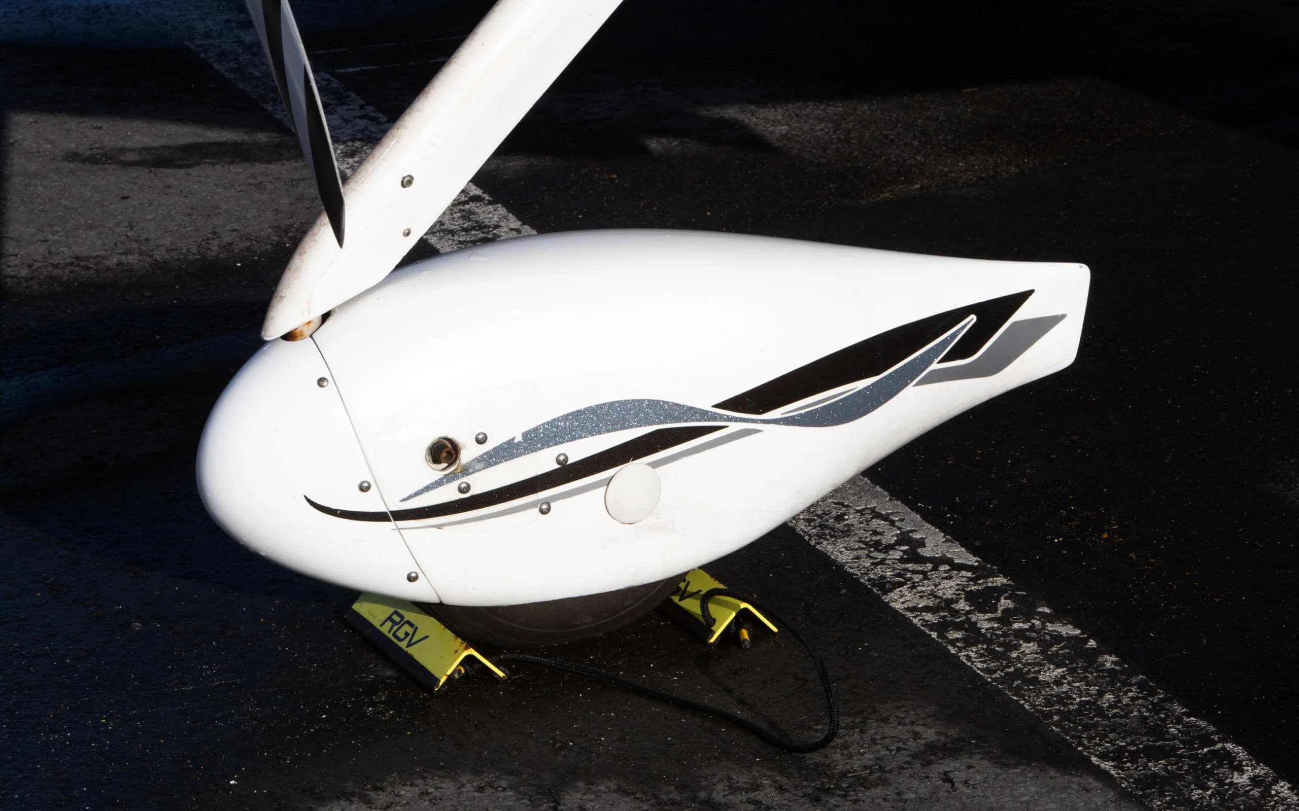 A close-up view of the white main landing gear fairing of a Cirrus SR22 G3 aircraft, showing black and grey stripe details.