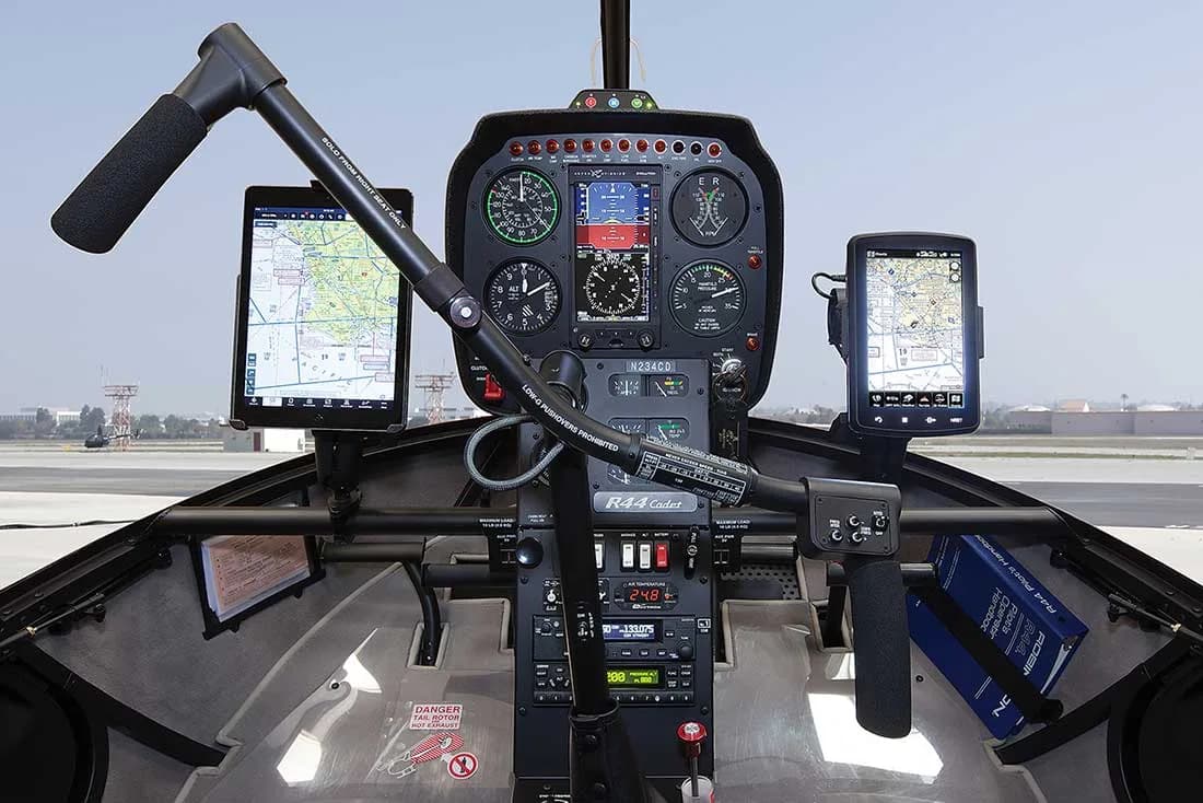 The cockpit of a Robinson R44 Cadet helicopter, showing the instrument panel and avionics.