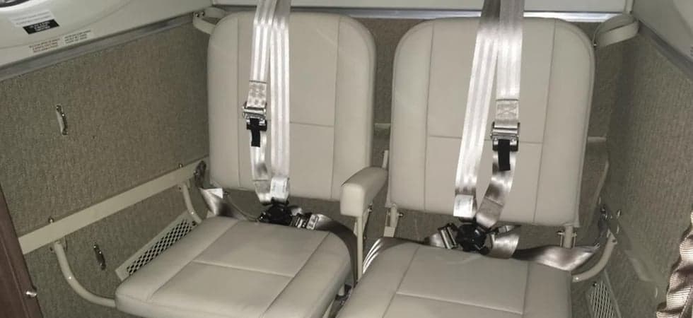Close-up of two leather seats with seatbelts in the aircraft's interior.