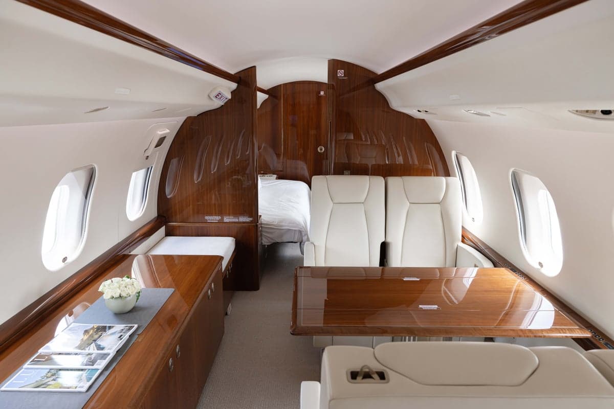 View of the aircraft interior with a bed and table.