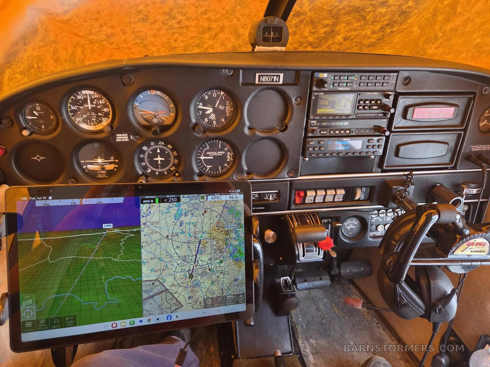 The full instrument panel of a Piper Cherokee 140 cockpit, featuring analog gauges, avionics, and a mounted tablet displaying a map.