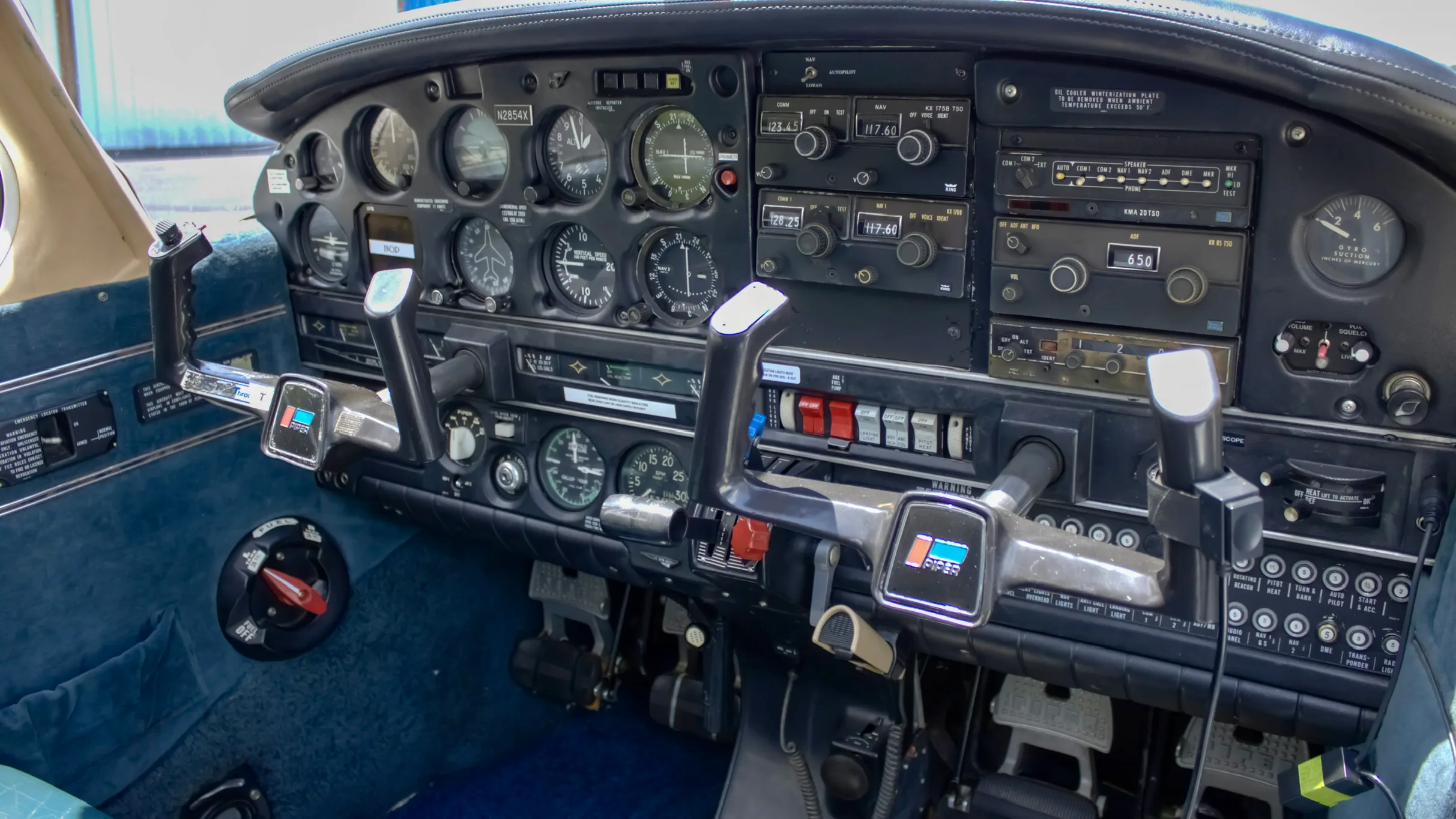 The instrument panel and dual yokes of a Piper Cherokee aircraft cockpit.