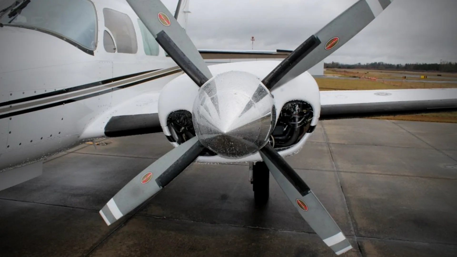Close-up of the propeller and nose of a white and black aircraft.