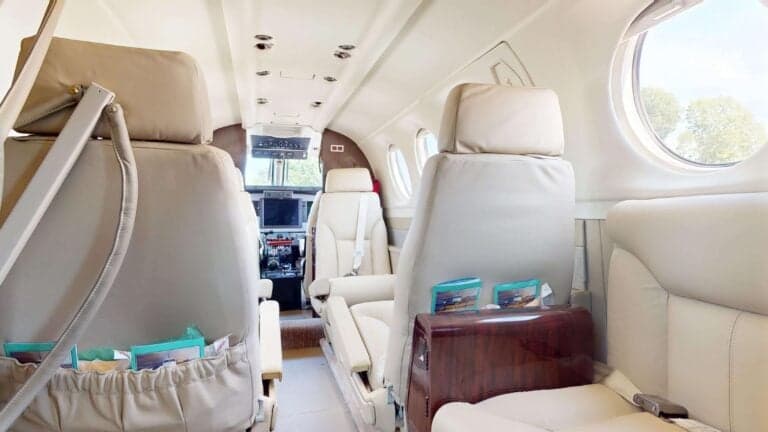 A view of the interior of a King Air aircraft with cream-colored leather seats.