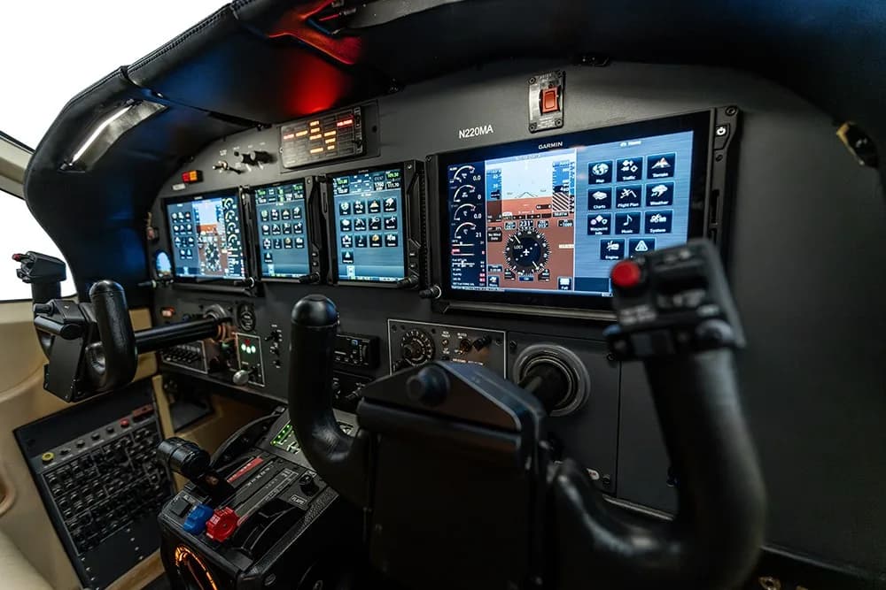 An angled view of the N220MA aircraft cockpit, showing the Garmin avionics suite.