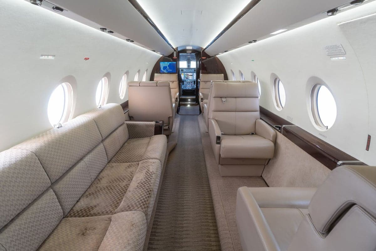 A view of the aircraft's interior with a sofa and leather seats.