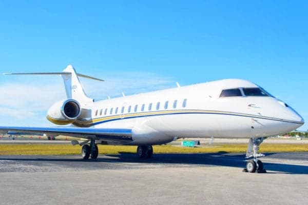 A white and gold Bombardier Global Express sits on the tarmac.
