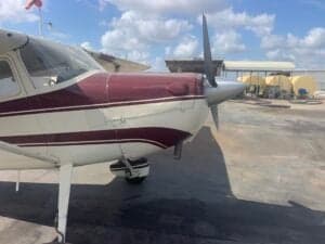 Close-up of the front of a Cessna 170A aircraft with a maroon and white paint scheme.