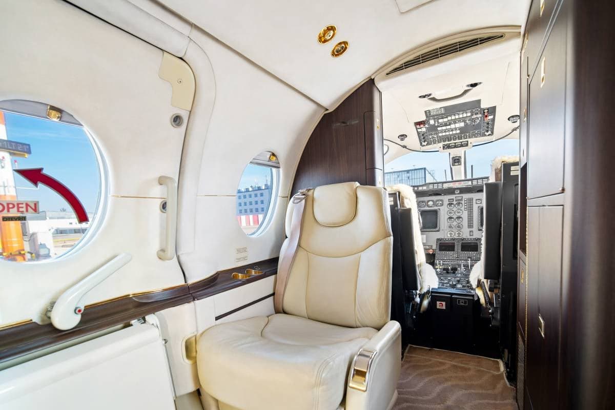 Interior view of the Beechcraft Beechjet 400A cabin showing a seat and the cockpit.