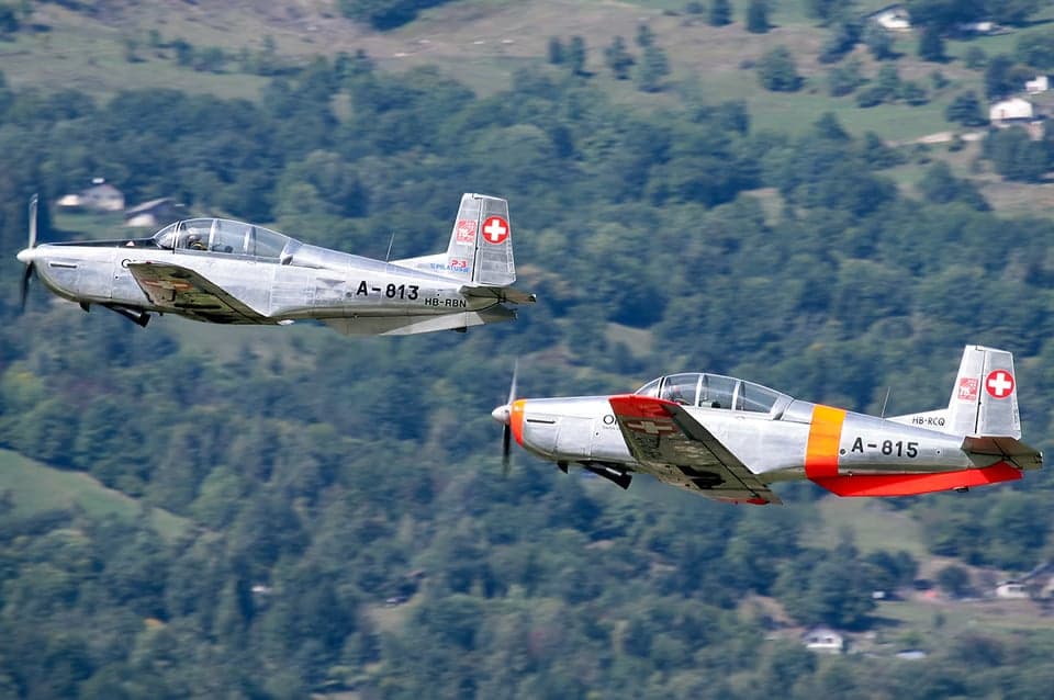 Pilatus PC-7 aircraft HB-RBN taking off from a grassy field.