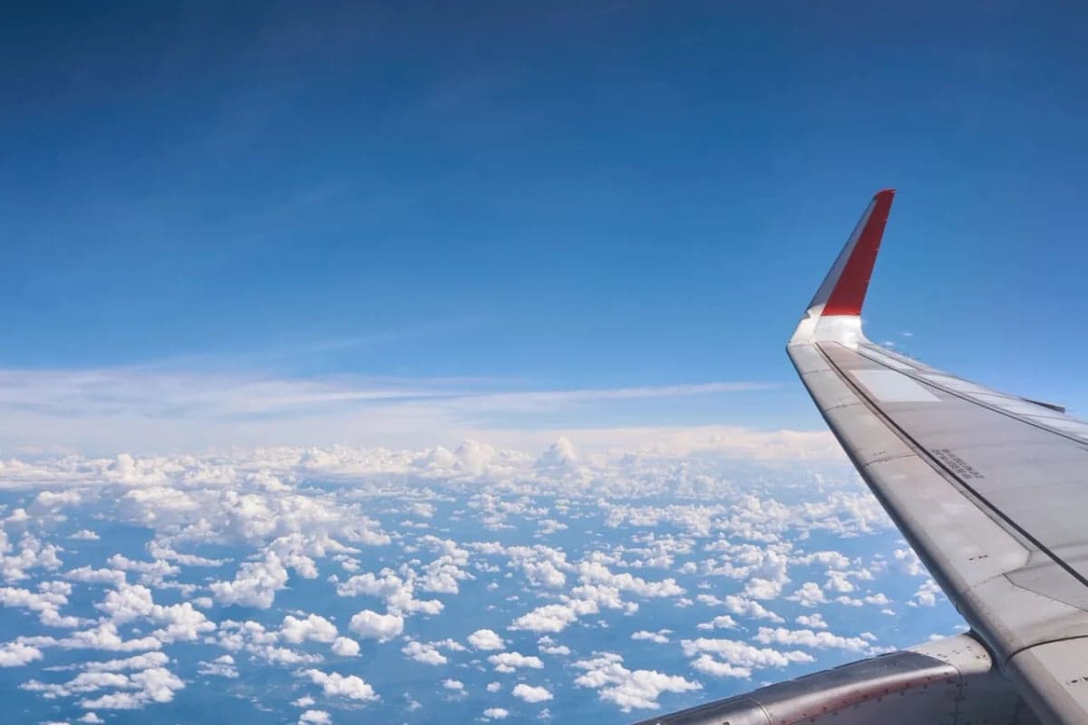 View of the wing of an aircraft flying above the clouds.