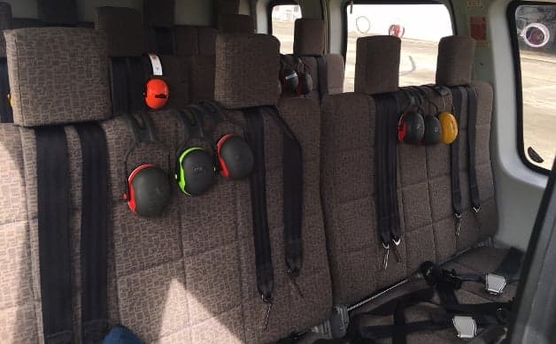 Interior view of the helicopter cabin with seats and headsets.