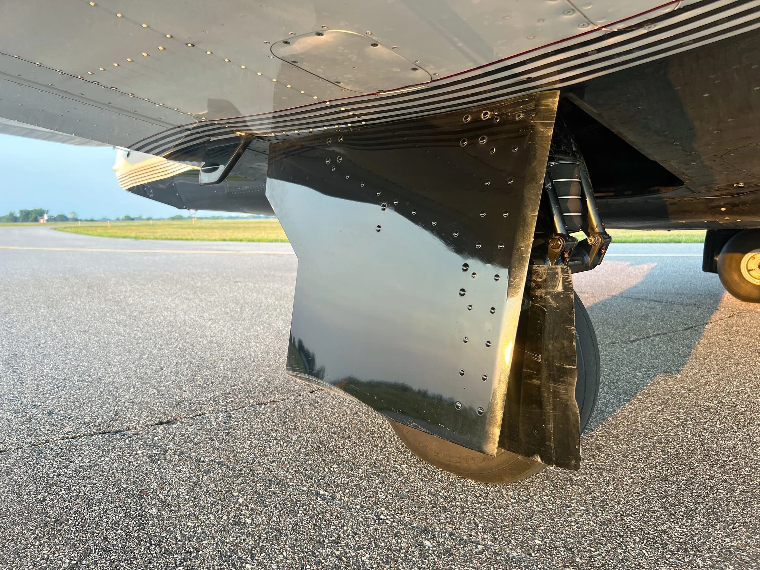 A close-up view of the main landing gear and wheel fairing of the dark blue and white aircraft.