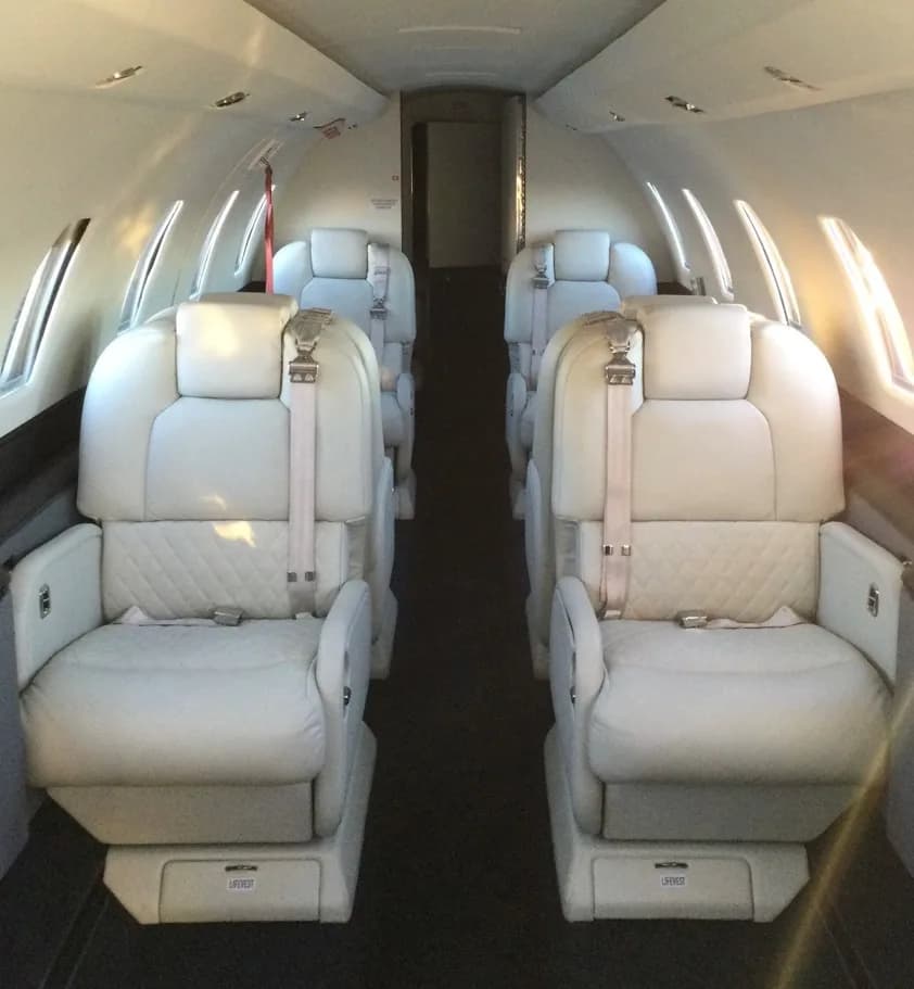View of the aircraft's interior with white leather seats.