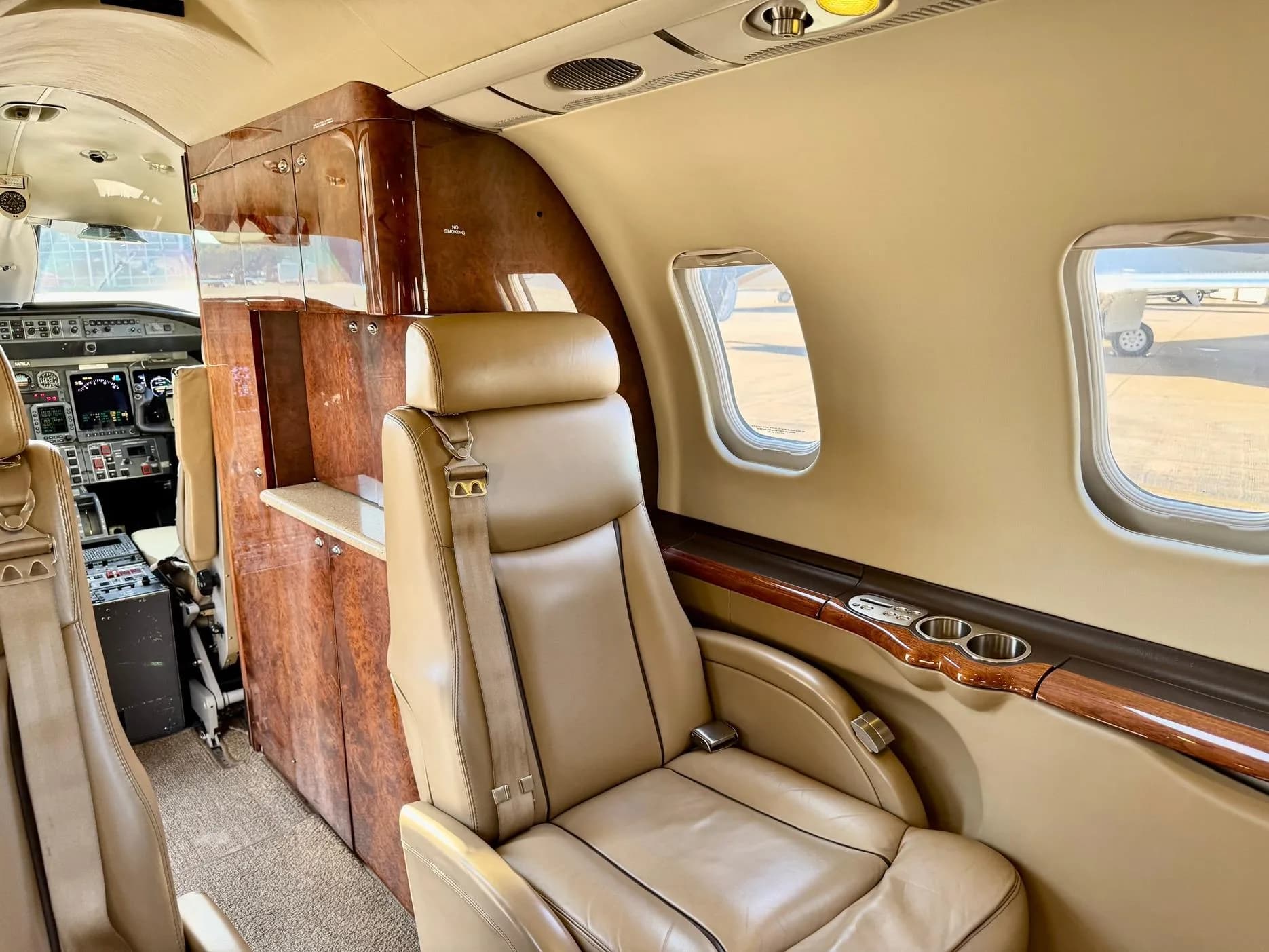 View of the aircraft interior with a seat and wood paneling.