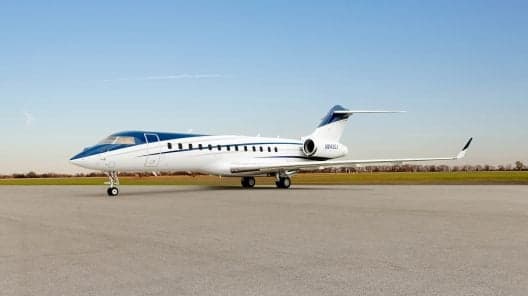 Gulfstream G450 on the tarmac with a white paint scheme and brown accent stripes.